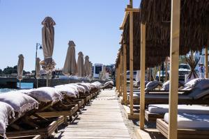 a row of umbrellas and chairs on a dock at Adriana beach in Pefkohori