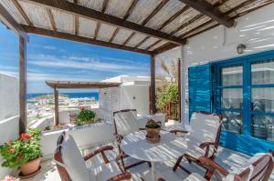 a patio with a table and chairs on a balcony at Chateau Zevgoli in Naxos Chora