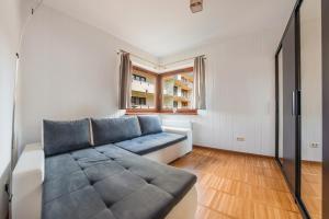 a living room with a blue couch and a window at Apartamenty Sun & Snow Helska Villa in Hel