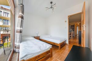 a bedroom with two beds and a table at Apartamenty Sun & Snow Helska Villa in Hel