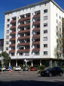 een groot wit gebouw met auto's geparkeerd op een parkeerplaats bij Ferienwohnung Messmer in Konstanz