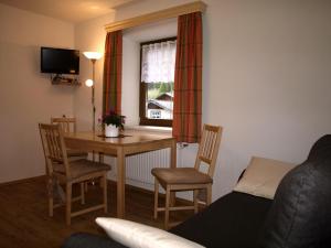 a living room with a table and chairs and a window at Xanderhof in Leutasch
