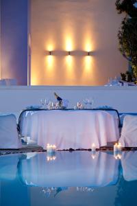 a dining room with a table and some lights at Acqua Vatos Santorini Hotel in Kamari