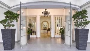 um corredor com dois vasos de plantas em vasos de vidro em Mikes Kanarium City Hotel em Larnaka
