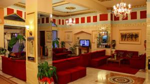 salon z czerwonymi kanapami i telewizorem w obiekcie Hotel Kosta Famissi w Kalambace