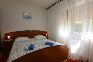 a bedroom with a bed with blue shoes on it at Apartment MIHAJIC M in Klimno