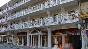 a large building with white balconies on a street at Hotel Kosta Famissi in Kalabaka