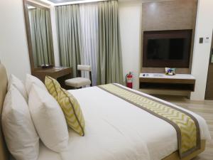a bedroom with a large white bed and a television at Boracay Haven Suites in Boracay