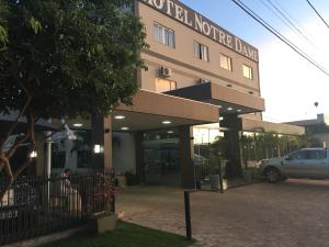 un edificio con un coche aparcado delante en Hotel Notre Dame, en Luís Eduardo Magalhães