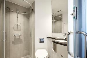 a bathroom with a shower and a toilet and a sink at Steel House Copenhagen in Copenhagen
