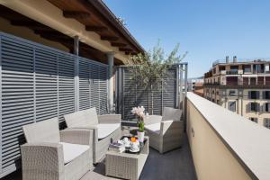 a balcony with chairs and tables on a building at Hotel Rapallo in Florence