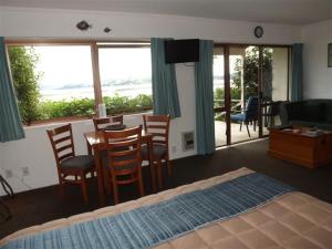 a bedroom with a bed and a table and chairs at Harbour View Motel in Coromandel Town