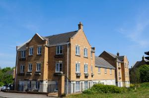 a large brown brick building with a black roof at Orchard Gate Apartments from Your Stay Bristol in Bristol