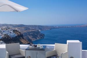 una mesa y sillas con vistas al océano en Dreams Luxury Suites, en Imerovigli