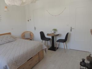 1 dormitorio con 1 cama, mesa y sillas en Le "Wood" en Annecy