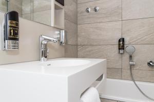 a bathroom with a white sink and a shower at Hotel Goldenes Rad in Ulm +13 photos