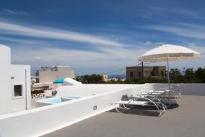 een zwembad met stoelen en een parasol op een dak bij Ayoba Santorini in Imerovígli