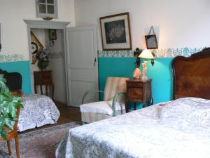- une chambre avec 2 lits et un mur bleu dans l'établissement Chambres d'hôtes la Graineterie, à Buxy