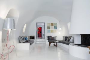 a white living room with two couches and a lamp at Alta Vista Suites in Firostefani