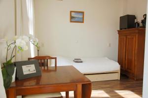 a bedroom with a bed and a desk and a table at Ensche-Day Inn in Enschede