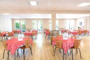 a room with tables and chairs with red tablecloths at Le Moulin de César in Vaison-la-Romaine