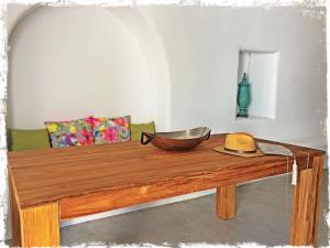 a wooden table topped with a bowl of fruit at Ayoba Santorini in Imerovigli