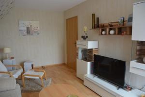sala de estar con TV de pantalla plana y sofá en Ferienwohnung Starke, en Gablenz