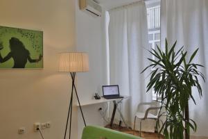 uma sala de estar com um computador portátil sobre uma mesa e uma planta em Apartment Alek em Belgrado