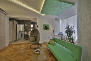 uma sala de estar com um sofá verde e uma cadeira em Apartment Alek em Belgrado