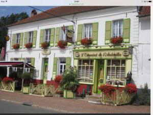 um grande edifício branco com persianas verdes numa rua em Baie de Somme Villa gros Becs em Dominois