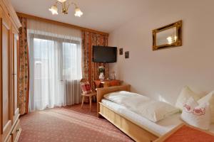En eller flere senge i et værelse på Hotel Standlhof Zillertal