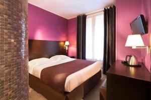 una habitación de hotel con una cama grande y paredes rosas en Hôtel Sophie Germain en París