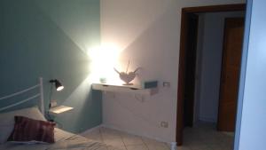 een slaapkamer met een bed en een lampje aan de muur bij Appartamento al Parco CIR03407AT00243 in Parma