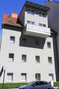 Appartementhaus Anna في لينز: مبنى ابيض كبير بسقف احمر