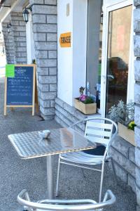 une table et des chaises devant un bâtiment dans l'établissement Le Ptit Ecureuil, à Tosse