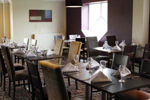 uma sala de jantar com mesas e cadeiras com copos de vinho em Citrus Hotel Coventry South by Compass Hospitality em Coventry