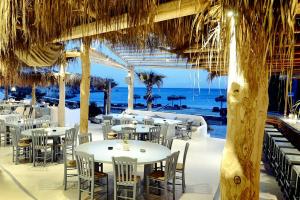 カロ・リヴァディにあるBeachfront Villa Amazing Views Mykonosの海とテーブルと椅子が備わるレストラン