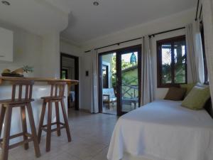 a bedroom with a bed and a table and chairs at Recanto da Mata Pipa in Pipa