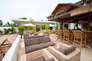 an outdoor patio with couches and tables and chairs at Bambu Hotel in Battambang