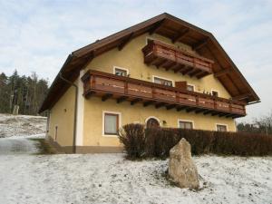 a house with a balcony on top of it in the snow at Apartment in Bleiburg near Petzen Ski Area in Bleiburg