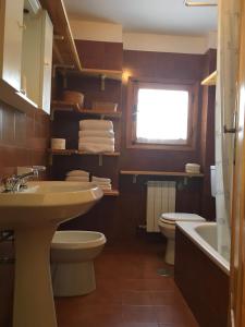 a bathroom with a sink and a toilet and a tub at Maison De Pitti in La Thuile