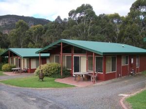 a red house with a green roof and a picnic table at Halls Gap Valley Lodges in Halls Gap