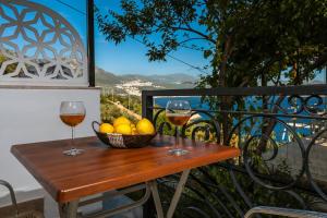 two glasses of wine and a basket of fruit on a table at Hamarat Otel in Kaş