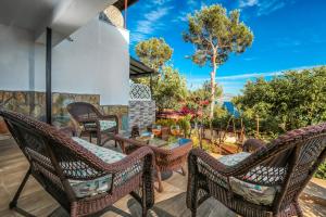 a patio with wicker chairs and a table at Hamarat Otel in Kaş