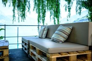 eine Couch auf einer Terrasse mit Blick auf das Wasser in der Unterkunft lofthotel Walensee in Murg + 40 Fotos