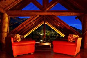 two red chairs in a room with a large window at Dos Bahias Lake Resort in Villa La Angostura