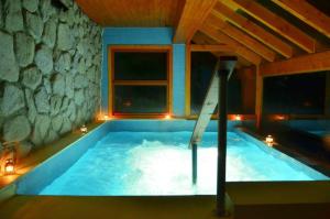 a large swimming pool in a room with a window at Dos Bahias Lake Resort in Villa La Angostura