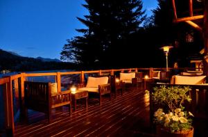 a deck with chairs and a table and lights at Dos Bahias Lake Resort in Villa La Angostura