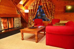 a living room with red furniture and a fireplace at Dos Bahias Lake Resort in Villa La Angostura