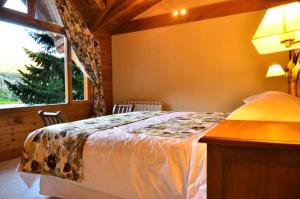 a bedroom with a bed and a large window at Dos Bahias Lake Resort in Villa La Angostura